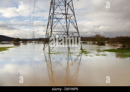 Strommasten stehen überflutete Landschaft im Tal des Flusses exe, bei Stoke Canon, bei Exeter, Devon, Großbritannien. Stockfoto