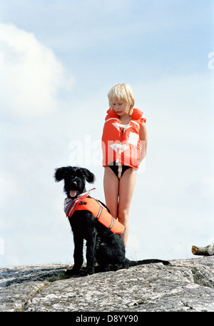 Mädchen und Hund Rettungswesten tragen. Stockfoto
