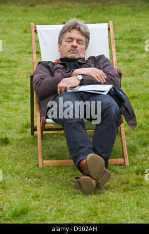 Mann schlafend im Liegestuhl auf Rasen an Hay Festival 2013 Hay on Wye Powys Wales UK Stockfoto