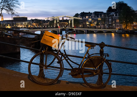 Niederlande, Amsterdam, Fahrrad und Magere Brug in der Dämmerung am Fluss Amstel Stockfoto