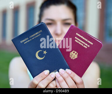 Student Merve Gul präsentiert einen German (R) und einen türkischen Pass in Stuttgart, Deutschland, 7. Juni 2013. Kurz vor einer Sitzung des Bundestages (FPK) auf die Frage der Doppelstaatsbürgerschaft sprach Wirtschaftsminister von Baden-Württemberg für die Gewährung von Menschen mit Migrationshintergrund doppelte Staatsbürgerschaften. Foto: BERND WEISSBROD Stockfoto