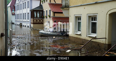 Friseur Ulrich Michel und seine Frau werden durch Oliver Jacob (R) in einem Schlauchboot zu ihren untergetauchten Shop getroffen als sie durch die überfluteten Straßen von Wehlen, Deutschland, 7. Juni 2013 schweben. Foto: Arno Burgi Stockfoto