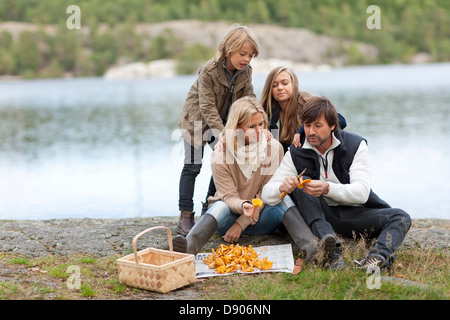 Eltern und 2 Kinder Pilze sammeln Stockfoto