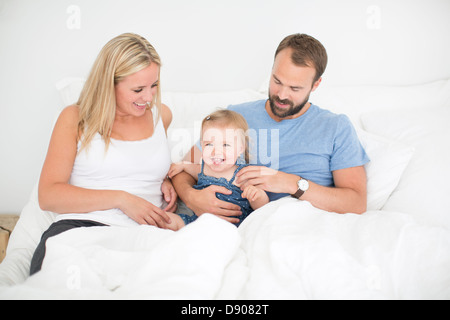 Glückliche Tochter, Mutter und Vater im Bett Stockfoto