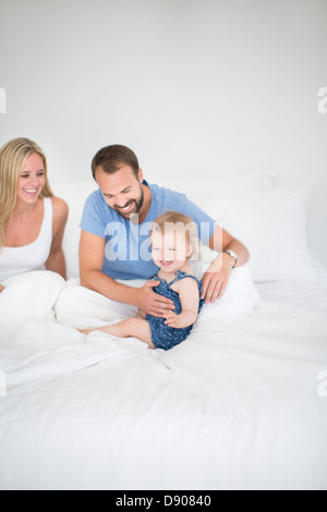 Eltern mit kleinen Tochter Entspannung im Bett Stockfoto