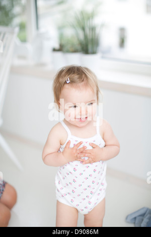 Kleines Mädchen lächelnd im Innenbereich Stockfoto