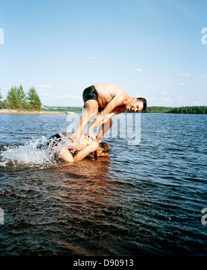Zwei Mann spielen im Wasser, Schweden lachen. Stockfoto