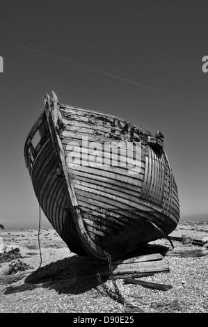 Eine verlassene Holzboot auf einem Kiesstrand in schwarz / weiß Stockfoto