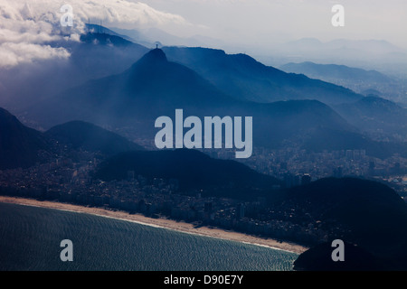 Blick aus der Vogelperspektive auf den Copacabana-Strand (Vordergrund), Christus den Erlöser auf dem Corcovado-Berg, umgeben vom Tijuca-Wald-Nationalpark und dem Botafogo-Viertel zwischen ihnen an einem nebligen und heißen Sommermorgen - hohe Luftfeuchtigkeit in der Luft. Rio de Janeiro, Brasilien. Stockfoto