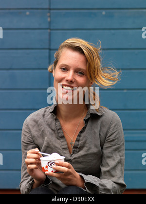 Lächelnde Frau essen Eis, Stockfoto