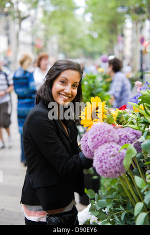Frau, die Blumen am Marktstand kaufen Stockfoto