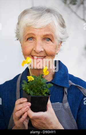 Eine ältere Frau, die eine Blume, Schweden. Stockfoto