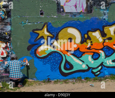 Graffiti-Künstler bei der Arbeit an einer Wand in Brighton Stockfoto