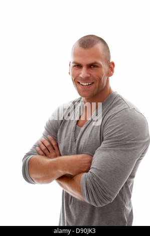 Junger Mann stand mit verschränkten Armen und lächelnd Stockfoto