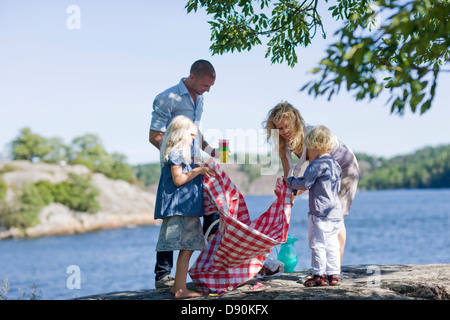 Familie Vorbereitung für Picknick am See Stockfoto