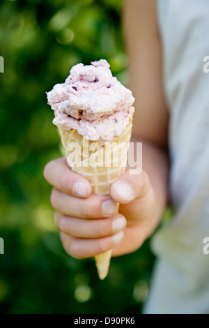 Childs Hand mit Eistüte Stockfoto
