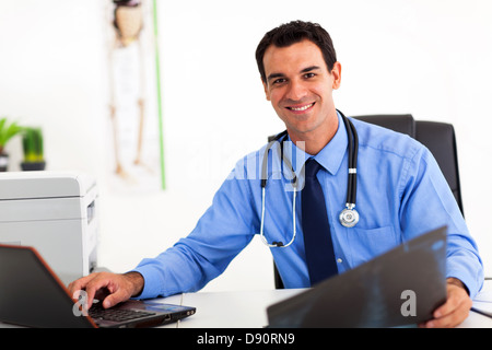 hübscher Arzt arbeiten im Büro Stockfoto