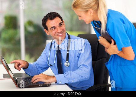 fröhliche männliche Doctror arbeiten mit Assistent im Büro diskutieren Stockfoto