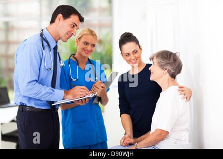 gut aussehend männlichen Arzt schreiben medizinische Verschreibung für ältere Patienten Stockfoto