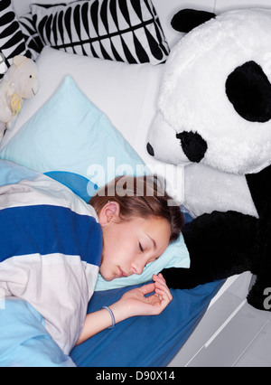 Mädchen mit Teddybär im Bett schläft Stockfoto