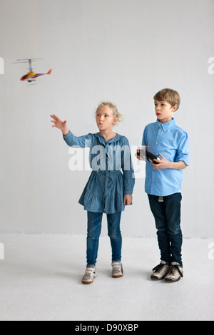 Jungen und Mädchen spielen mit Hubschrauber-Modell Stockfoto
