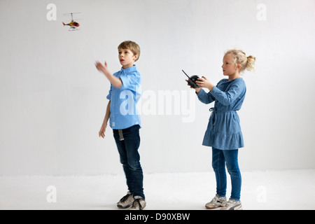 Jungen und Mädchen spielen mit Hubschrauber-Modell Stockfoto