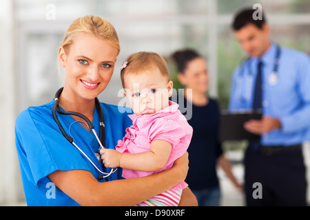 schöne weibliche Krankenschwester hält Babymädchen im Krankenhaus Stockfoto