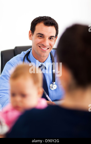 lächelnde Kinderarzt Gespräch mit Baby Patient Mutter im Büro Stockfoto