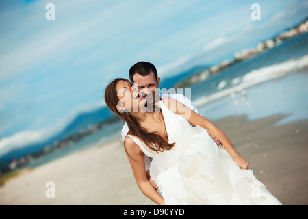 Brautpaar am Strand umarmen Stockfoto