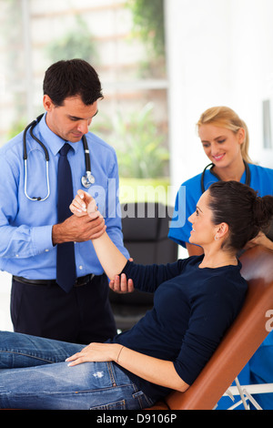 Orthopäde untersuchen junge Frau arm Stockfoto