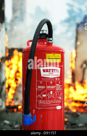 Nahaufnahme von Feuerlöscher, Flammen im Hintergrund Stockfoto
