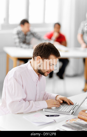 Student mit Laptop in der Bibliothek Stockfoto