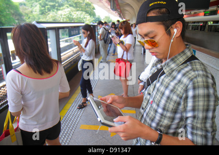 Singapur SMRT, East West Green Line, Tanah Merah Station, Schnellverkehr, asiatischer Mann Männer, Passagierfahrer Fahrer, Fahrer, Plattform, mit, Ein Stockfoto