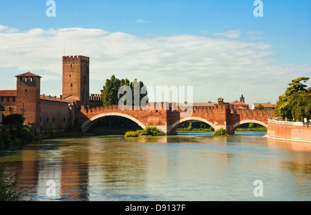 Flussufer-Blick auf die berühmten The Castelvecchio Brücke in Verona, Italien in einem sonnigen Tag mit weißen Wolken in der Ferne. Stockfoto