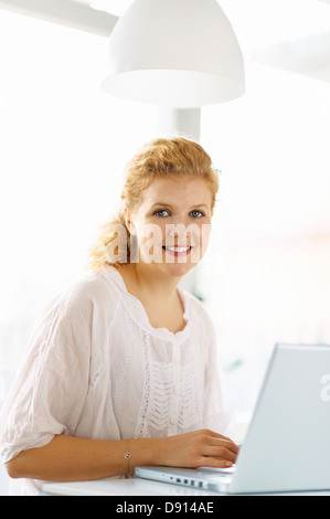 Junge Frau am Laptop arbeiten Stockfoto