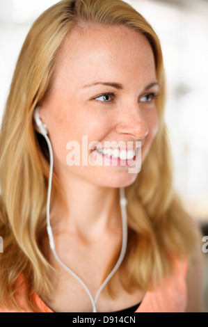 Lächelnde junge Frau Musik hören Stockfoto
