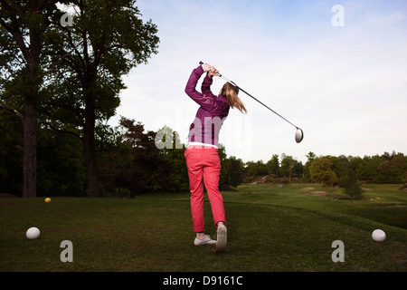 Junge Frau am Golfplatz spielen Stockfoto