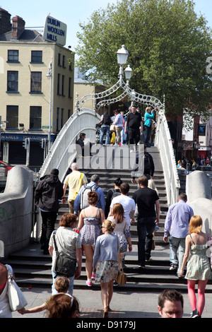 Bettler unter den Massen auf Halfpenny Bridge, Dublin, Irland Stockfoto