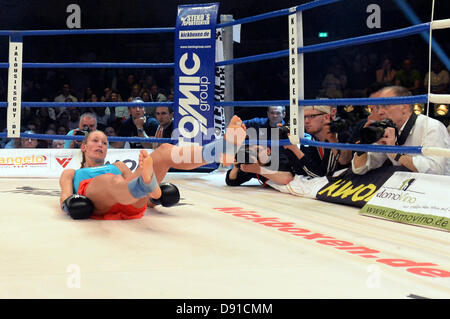 Deutschen Kickboxer Christine Theiss fällt auf den Boden des Ringes während eines Kampfes gegen Stavrova aus Russland bei Stekos Fight Night im Circus Krone in München, 7. Juni 2013 statt. Theiss verlor den Kampf und damit auch ihren Weltmeistertitel. Foto: Felix Hoerhager Stockfoto