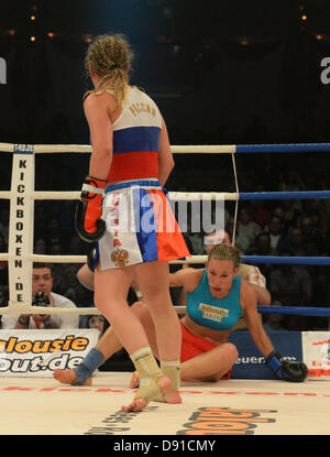 Deutsche kick Boxer Christine Theiss (R) fällt auf den Boden während ihres Kampfes gegen Olga Stavrova aus Russland bei Stekos Fight Night im Circus Krone in München, 7. Juni 2013 statt. Theiss verlor den Kampf und damit auch ihren Weltmeistertitel. Foto: Felix Hoerhager Stockfoto