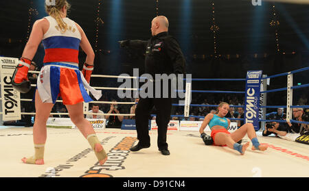 Deutsche kick Boxer Christine Theiss (R) fällt auf den Boden während ihres Kampfes gegen Olga Stavrova aus Russland bei Stekos Fight Night im Circus Krone in München, 7. Juni 2013 statt. Theiss verlor den Kampf und damit auch ihren Weltmeistertitel. Foto: Felix Hoerhager Stockfoto