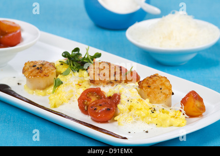 Safran-Risotto mit gegrillten Jakobsmuscheln und Cherry-Tomaten-sauce Stockfoto