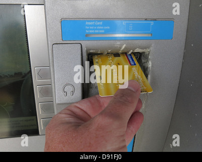 Eine Nationwide-Kontokarte in einen Geldautomaten der Genossenschaft stecken, gelb Stockfoto
