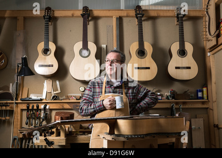 Gitarrenbauer stehen in Werkstatt, wegschauen Stockfoto