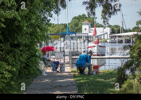 Zwei Männer, ein Kaukasier, ein Afroamerikaner, fischen von der Küste am See Hefner, Oklahoma City, Oklahoma USA im Marina-Bereich. Stockfoto