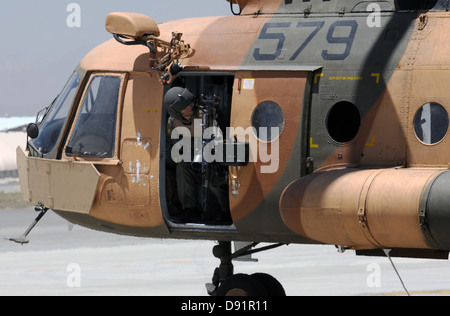 Einer afghanischen Luftwaffe Antenne Kanonier löscht links von seinem Mi-17 Hubschrauber, als sie in einem Mi-17 Hubschrauber in Air Assault Mission 29. Mai 2013 am internationalen Flughafen von Kabul, Afghanistan ausziehen. Stockfoto