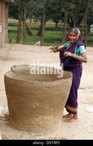 Frau macht riesigen Glas in ihrem Hof, Bangladesch Stockfoto