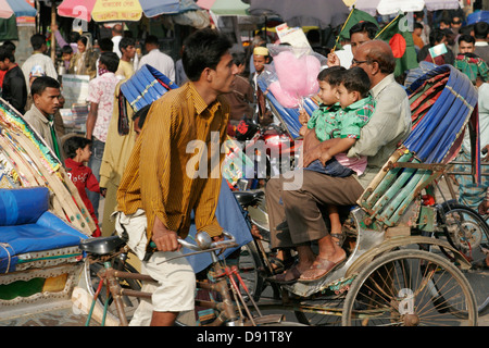 Rikschas, die Passagiere auf der belebten Straße Bogra, nördlich von Bangladesch Stockfoto