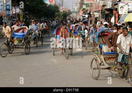 Rikschas, die Passagiere auf der belebten Straße Bogra, nördlich von Bangladesch Stockfoto