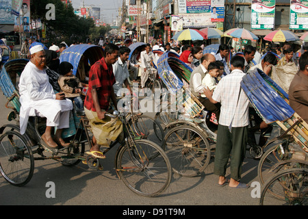 Rikschas, die Passagiere auf der belebten Straße Bogra, nördlich von Bangladesch Stockfoto